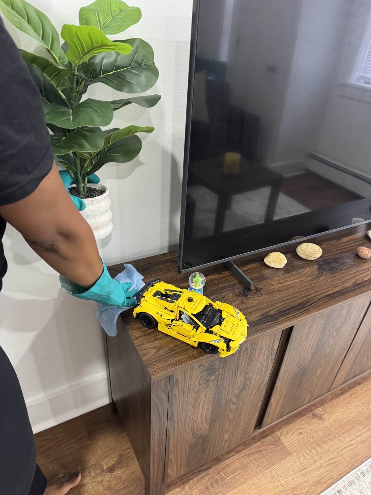 Wiping down a console table and decor with a microfiber cloth